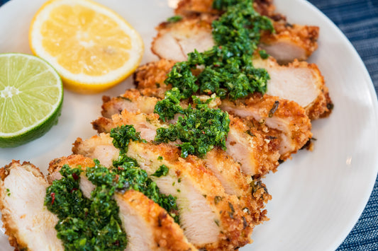 Crispy, Golden Breaded Pork Chop with Savory Herb Crust, Drizzled with Zesty Chimi-Green Sauce